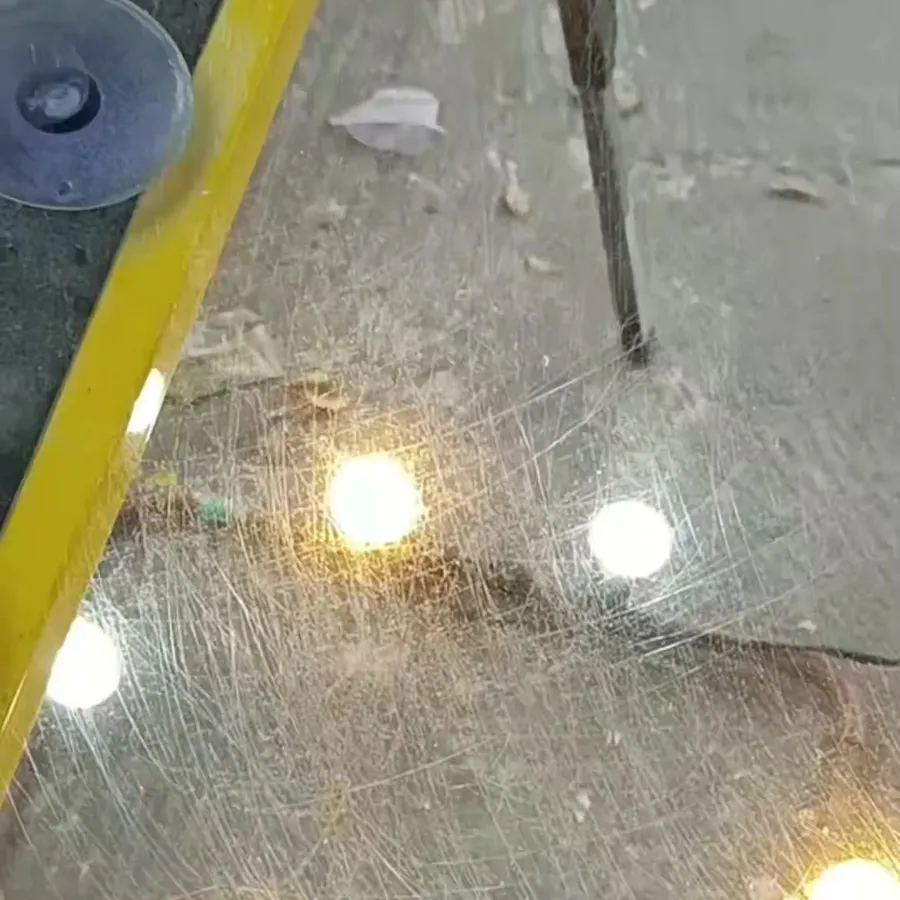 Vidro automotivo com riscos densos, sob barra de luz