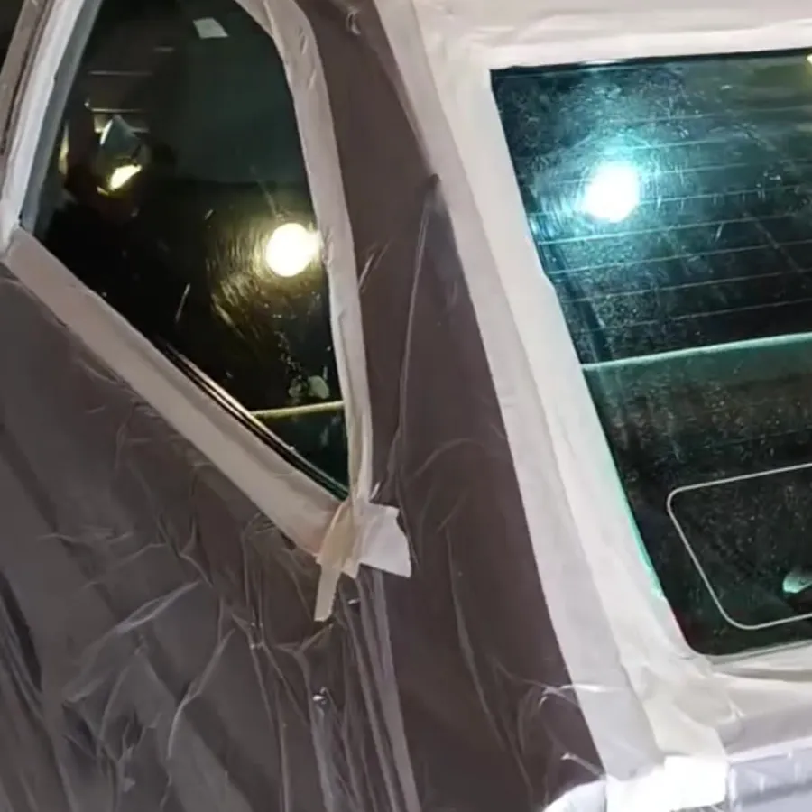 Porta de carro coberta com plástico e fita antes do trabalho no vidro